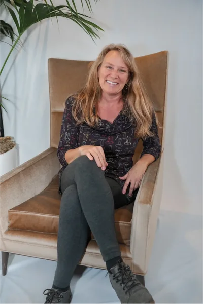 Portrait of artist Jennifer Patten seated in an armchair
