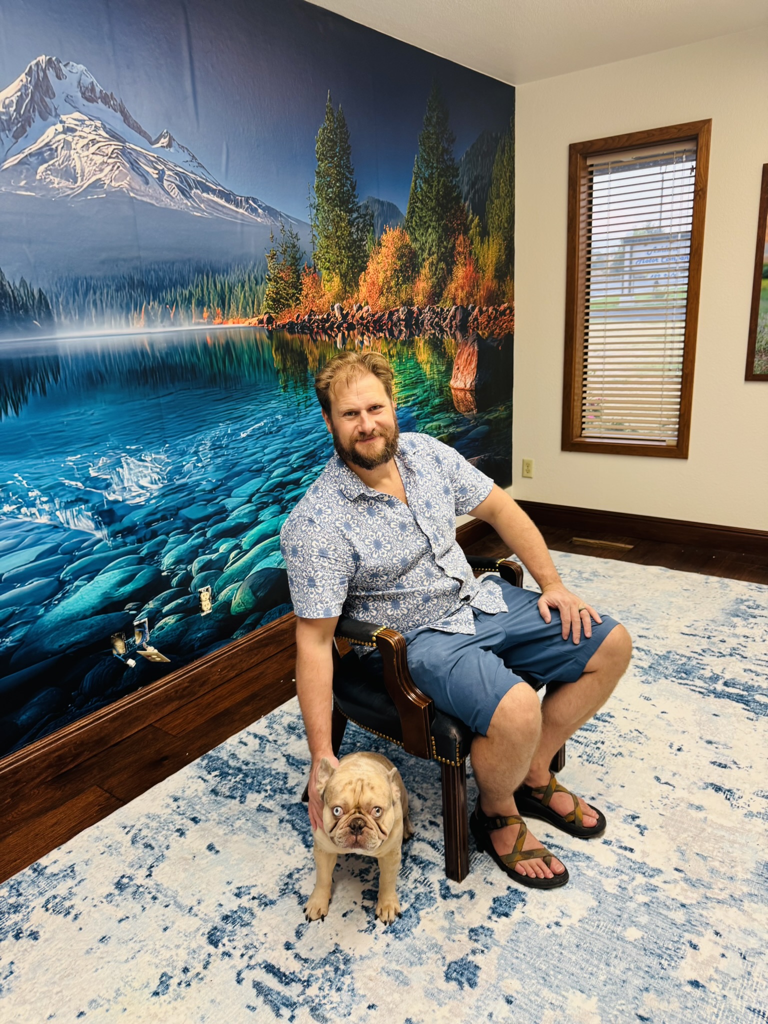 Client and dog in front of the finished mountain lake mural